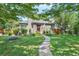 Charming home featuring a well-manicured lawn, stone walkway, and inviting front porch with an American flag at 675 Dahlia St, Denver, CO 80220