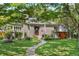 Charming home featuring a well-manicured lawn, stone walkway, and inviting front porch with an American flag at 675 Dahlia St, Denver, CO 80220