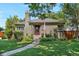 Charming home featuring a well-manicured lawn, stone walkway, and inviting front porch with an American flag at 675 Dahlia St, Denver, CO 80220
