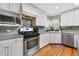 Bright kitchen featuring stainless steel appliances, tile backsplash, and ample counter space at 675 Dahlia St, Denver, CO 80220
