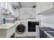 A laundry room with a washing machine, dryer, sink, and shelving for storage at 675 Dahlia St, Denver, CO 80220