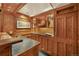 Basement wet bar with wood cabinetry, lighting, and tile countertop at 675 Dahlia St, Denver, CO 80220