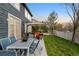 Beautifully landscaped backyard with a dining table, patio, seating area with a fire pit, and a privacy fence at 5910 W Sumac Ave, Littleton, CO 80123