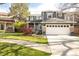 Attractive two-story home with a well-maintained lawn, mature trees, and a white garage door with stone accents at 5910 W Sumac Ave, Littleton, CO 80123