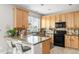 Functional kitchen features wood cabinets, dark appliances, and a breakfast bar at 5910 W Sumac Ave, Littleton, CO 80123
