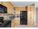 Kitchen featuring wooden cabinets, black appliances, and ample counter space at 5910 W Sumac Ave, Littleton, CO 80123