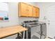 A well-equipped laundry room featuring a washer, dryer, folding table and upper cabinets at 5910 W Sumac Ave, Littleton, CO 80123