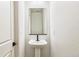 Small bathroom features a pedestal sink, black hardware and a large mirror at 4371 Soapberry Pl, Castle Rock, CO 80108