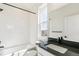 The bathroom is equipped with a tiled shower-tub combination, a vanity with a black countertop, and a framed mirror at 4371 Soapberry Pl, Castle Rock, CO 80108