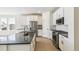 This kitchen is equipped with white cabinets, stainless steel appliances, an island, and a breakfast bar at 4371 Soapberry Pl, Castle Rock, CO 80108