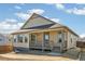 A rear exterior view of a tan home featuring a cozy porch and a well-manicured yard at 4371 Soapberry Pl, Castle Rock, CO 80108