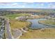 Beautiful aerial view of green space, a pond, and walking paths, near a school and many homes at 15842 E Warner Dr, Denver, CO 80239