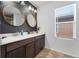 Bathroom with double vanity, large mirrors, and dark cabinets at 15842 E Warner Dr, Denver, CO 80239