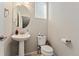 Small bathroom with pedestal sink, toilet, and window at 15842 E Warner Dr, Denver, CO 80239