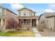 Charming two-story home featuring a cozy front porch and well-maintained landscaping at 15842 E Warner Dr, Denver, CO 80239