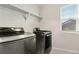 Bright laundry room, featuring LG washer and dryer, and overhead shelving at 15842 E Warner Dr, Denver, CO 80239