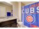 Bathroom with granite vanity, mirror, toilet, and a shower with a Chicago Cubs-themed curtain at 4316 S Netherland St, Aurora, CO 80015
