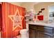 This bathroom includes a red star themed shower curtain and black cabinet at 4316 S Netherland St, Aurora, CO 80015