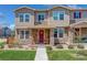 Charming townhome with a red door, stone accents, and inviting front porch with rocking chairs at 4316 S Netherland St, Aurora, CO 80015