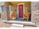 Inviting front porch with stone pillars, rocking chairs, and charming decor at 4316 S Netherland St, Aurora, CO 80015
