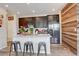 Eat-in kitchen features dark cabinetry, stainless appliances and a stone countertop island with seating at 4316 S Netherland St, Aurora, CO 80015