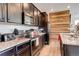 Modern kitchen features stainless appliances, dark cabinets, stone countertops, and rustic wood accent wall at 4316 S Netherland St, Aurora, CO 80015