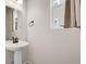 Simple powder room features a pedestal sink, bronze fixtures, and natural light from a window at 4358 S Nepal Ct, Centennial, CO 80015