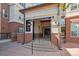 Close up exterior of building entrance with brick facade, stairs, and covered entry for Buildings A and B at 5677 S Park Pl # A102, Englewood, CO 80111