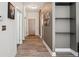 Hallway features wood-look floors, neutral walls, shelving, and multiple doors leading to other rooms at 5677 S Park Pl # A102, Englewood, CO 80111