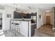 Modern kitchen with dark cabinets, stainless steel appliances, bar seating, and wood-look floors at 5677 S Park Pl # A102, Englewood, CO 80111