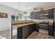 Bright kitchen featuring stainless steel appliances, stone countertops, wood-look floors, and natural light at 5677 S Park Pl # A102, Englewood, CO 80111