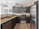 Well-equipped kitchen with stainless steel appliances, wood-look floors, and granite countertops at 5677 S Park Pl # A102, Englewood, CO 80111