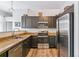 Modern kitchen with stainless steel appliances, ample counter space, and dark wood cabinets at 5677 S Park Pl # A102, Englewood, CO 80111