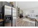 Bright living room featuring hardwood floors, modern decor, and a stainless steel refrigerator in kitchen at 5677 S Park Pl # A102, Englewood, CO 80111