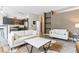 Spacious living room with modern sofas, an open kitchen, and stylish decor elements throughout the living space at 5677 S Park Pl # A102, Englewood, CO 80111