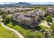 A high-angle view of a home with stone detailing, nice landscaping and mountain views in the distance at 2373 S Joyce St, Denver, CO 80228