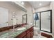 Well-lit bathroom showcases a granite countertop, frameless shower, and neutral color scheme at 2373 S Joyce St, Denver, CO 80228