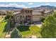 Home with stone accents, a well-manicured lawn, and mountain views in the background at 2373 S Joyce St, Denver, CO 80228