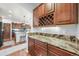 Butler's pantry area with matching granite counters, dark wood cabinets and wine rack at 2373 S Joyce St, Denver, CO 80228