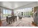 Open-concept dining and living area with tall ceilings, lots of natural light, and stone fireplace at 2373 S Joyce St, Denver, CO 80228