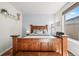 Comfortable bedroom boasts a large wooden bed frame, stylish decor, and lots of natural light at 2373 S Joyce St, Denver, CO 80228