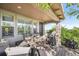 Covered outdoor patio with dining and lounge seating, a built-in grill, and stone accents at 2373 S Joyce St, Denver, CO 80228