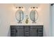 A bathroom has double sinks, modern fixtures, and framed mirrors at 16685 Trail Sky Cir, Parker, CO 80134