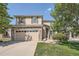 Two-story home featuring a brick and siding exterior, attached garage, and well-maintained lawn, exuding curb appeal at 16685 Trail Sky Cir, Parker, CO 80134