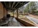 Covered brick patio with table, chairs, grill, and view of the lawn and driveway at 5382 S Pine Rd, Evergreen, CO 80439