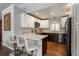 Modern kitchen with white cabinets, stainless steel appliances, and a breakfast bar with stools at 5382 S Pine Rd, Evergreen, CO 80439