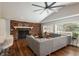 Spacious living room with a brick fireplace, hardwood floors, and a large sectional sofa at 5382 S Pine Rd, Evergreen, CO 80439
