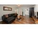 Cozy living room featuring hardwood floors, a comfortable black sectional sofa and access to the kitchen at 5382 S Pine Rd, Evergreen, CO 80439
