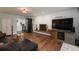 Spacious living room featuring hardwood floors, fireplace, and a large TV with a modern entertainment center at 5382 S Pine Rd, Evergreen, CO 80439