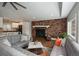 Modern living room featuring a brick fireplace, hardwood floors, and an open floor plan at 5382 S Pine Rd, Evergreen, CO 80439